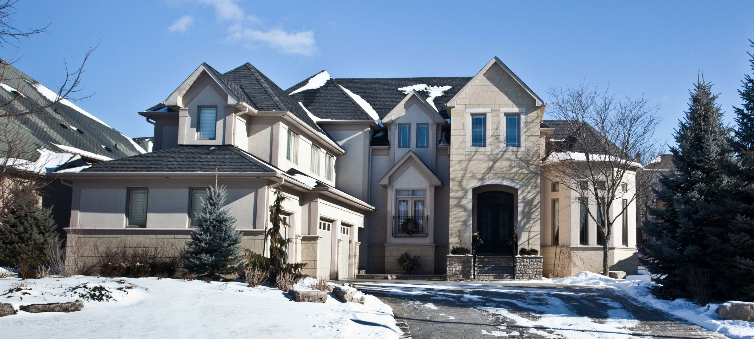 Home surrounded by snow on the ground and on the roof